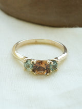 Shown: BIZARRE Y - $2500 - One of a kind Vega 3 Stone Ring. Unique 0.75ct orange/brown/purple center stone with green side stones. 14k yellow gold. Smooth texture. Polish finish. Size 6. 